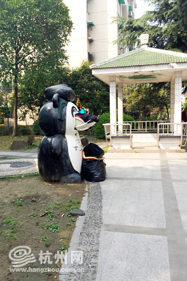 “大熊猫”不仅头顶衣物，连脚下都堆满着被打包的衣物，还有一件衣服被翻出在外。